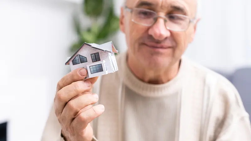 Home Equity - Senior holding a small house